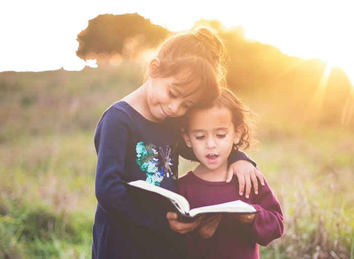 Kids reading a book in a field